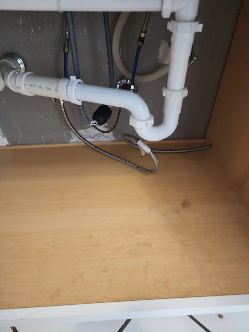 Inside of an under-sink cabinet cleaned during a move-out cleaning